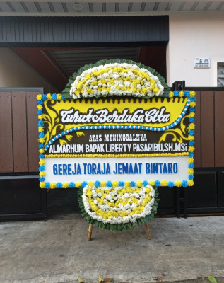 Papan Bunga Duka di Harapan Baru